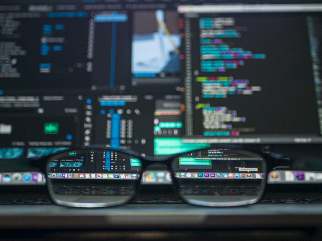 eye glasses in front of computer screens with lots of data visible