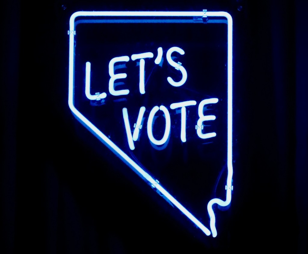 interactive marketing: an illuminated sign reads "let's vote" in pale blue text