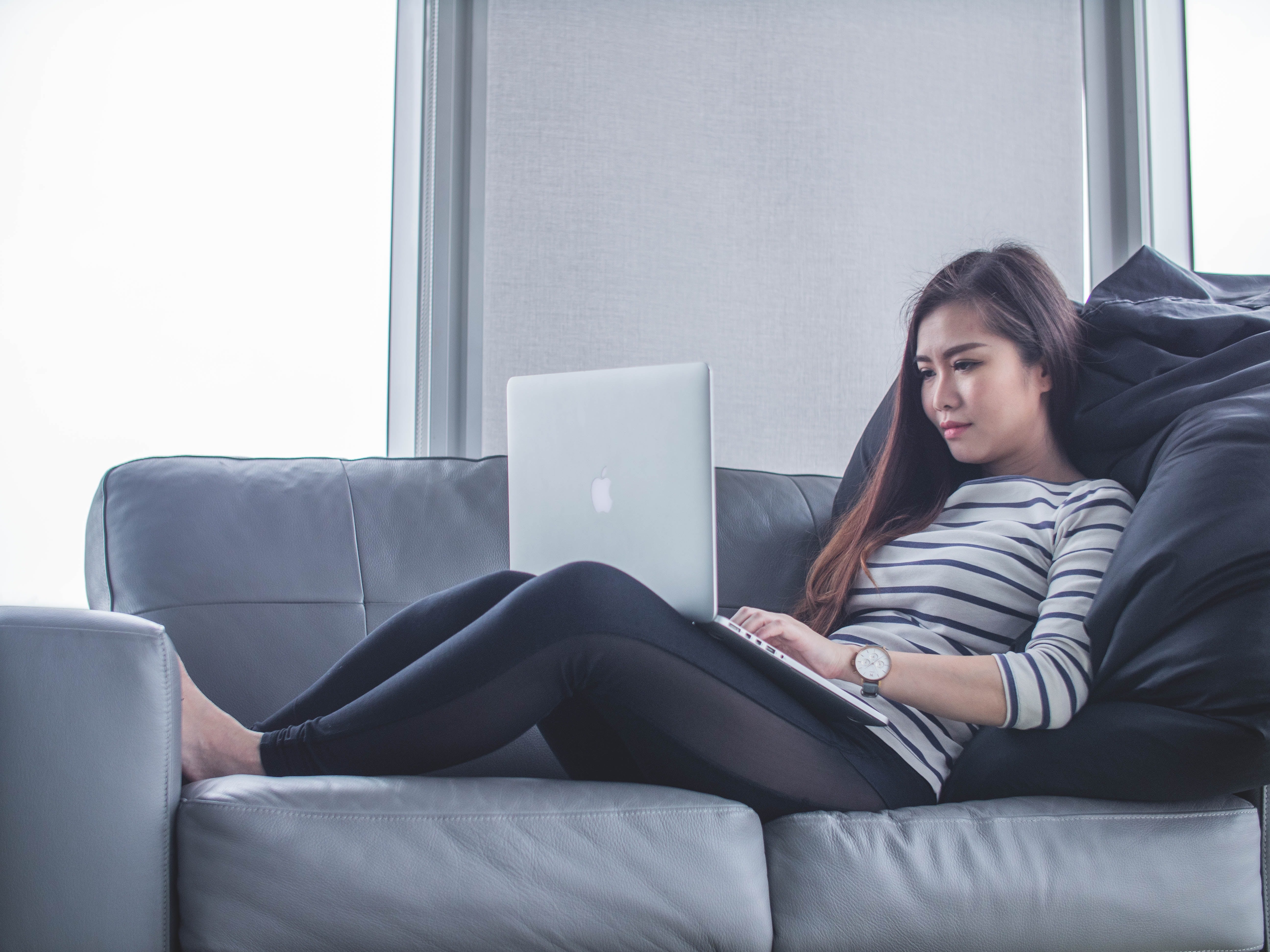 in-house content creation: woman sitting on sofa with laptop