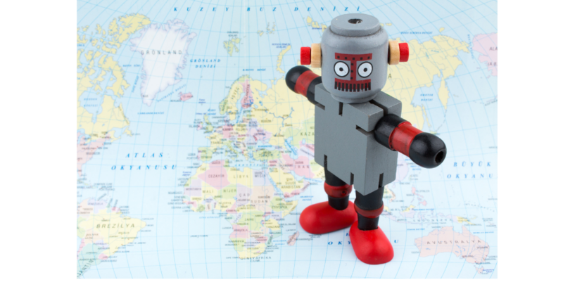 A toy robot standing on a world map