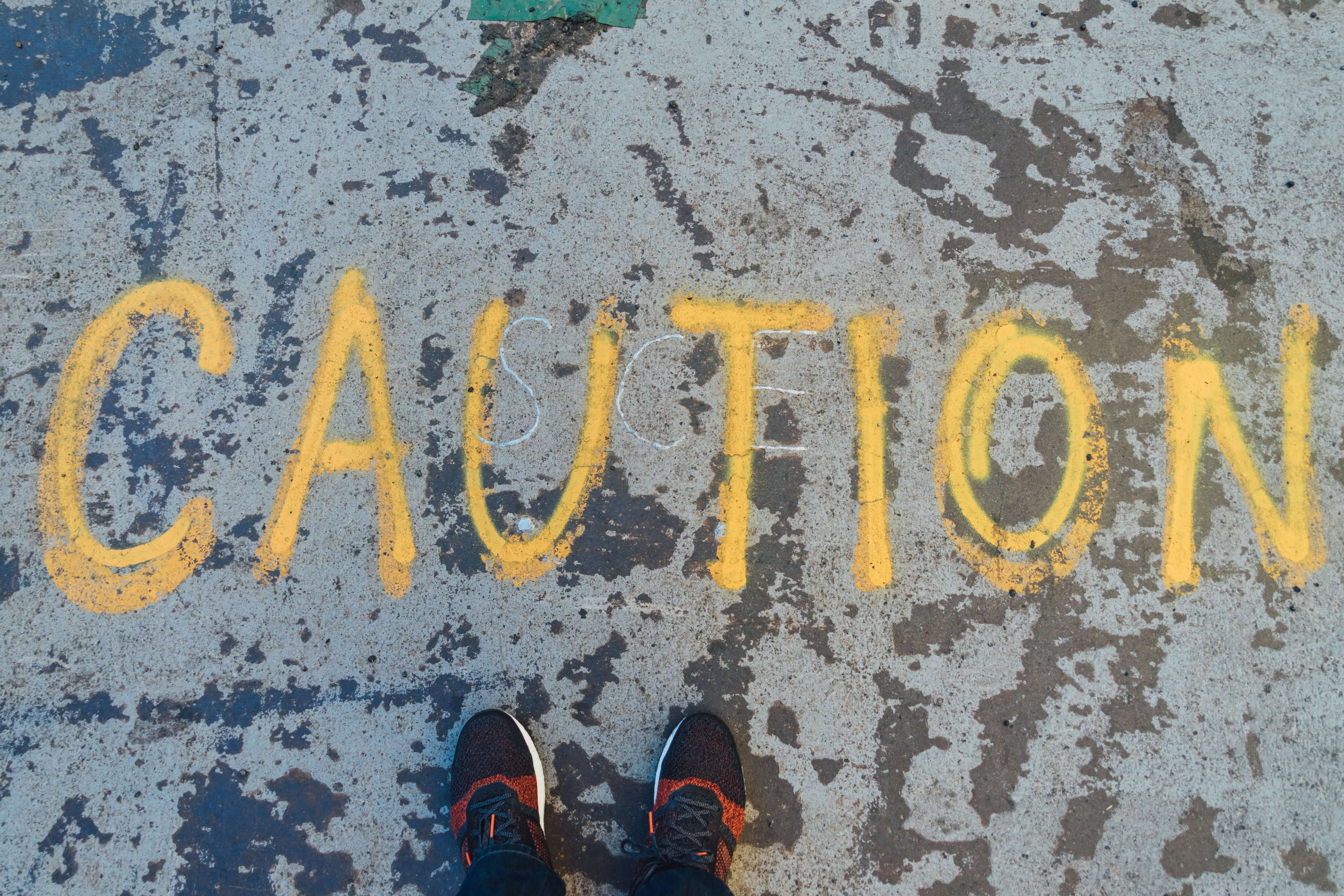 The word "caution" is painted on a concrete floor