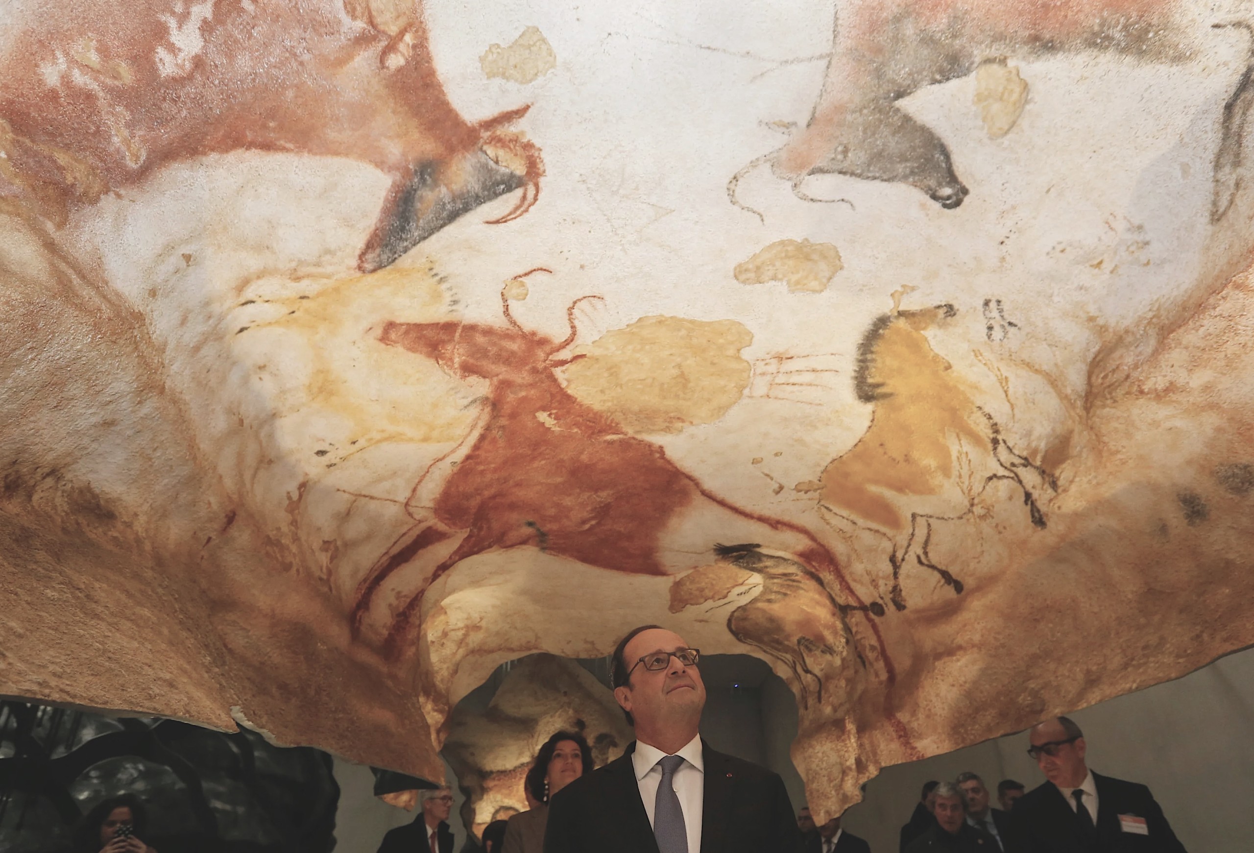 business man admiring cave drawings, the first example of visual storytelling