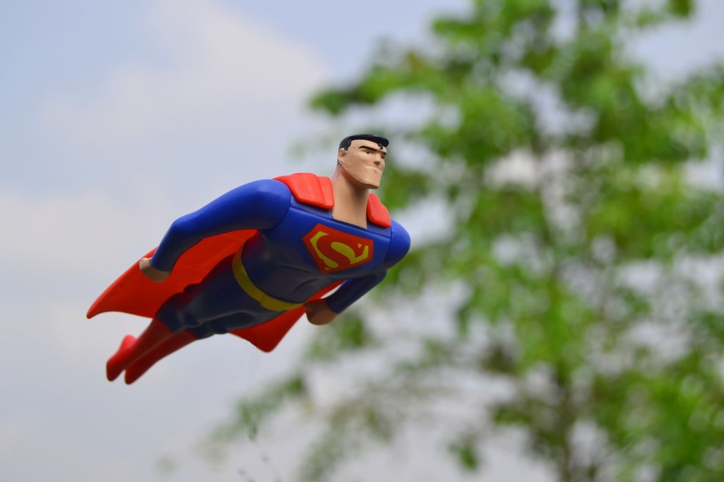 superman doll flying through sky