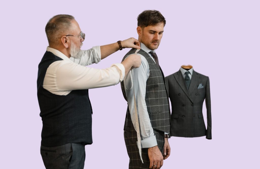 A tailor measuring a man for a suit