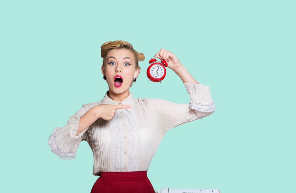 woman looking surprised holding a clock