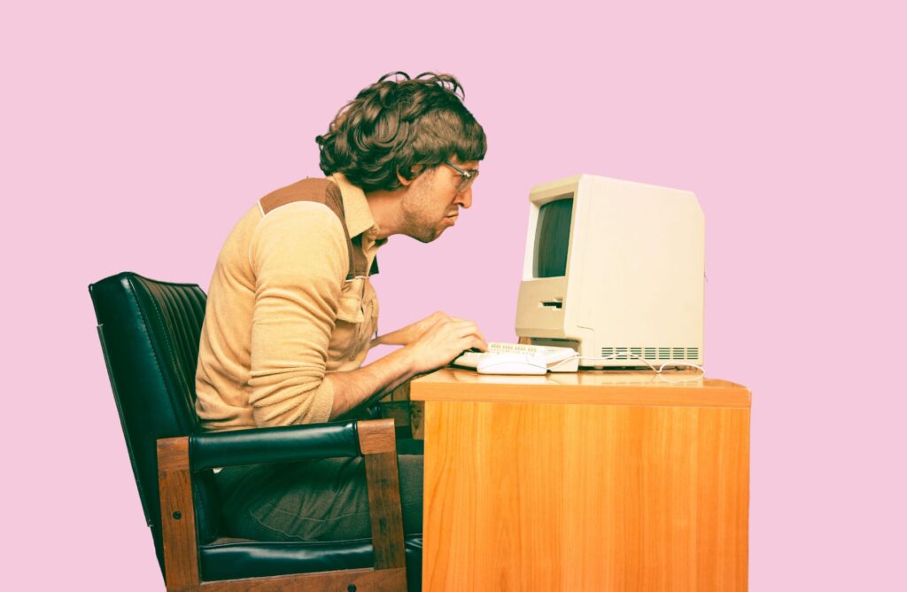 Retro image of man looking at a computer at his desk